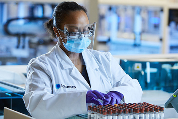 Labcorp scientist placing test tubes on a tray