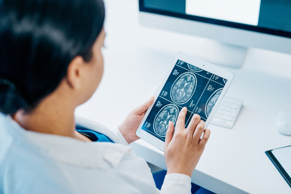 Shot of a young doctor analysing brain scans on a digital tablet