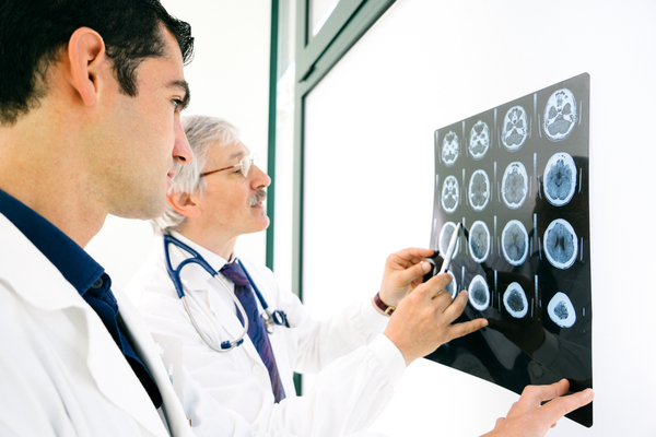 Doctors consult over an MRI scan of the brain.