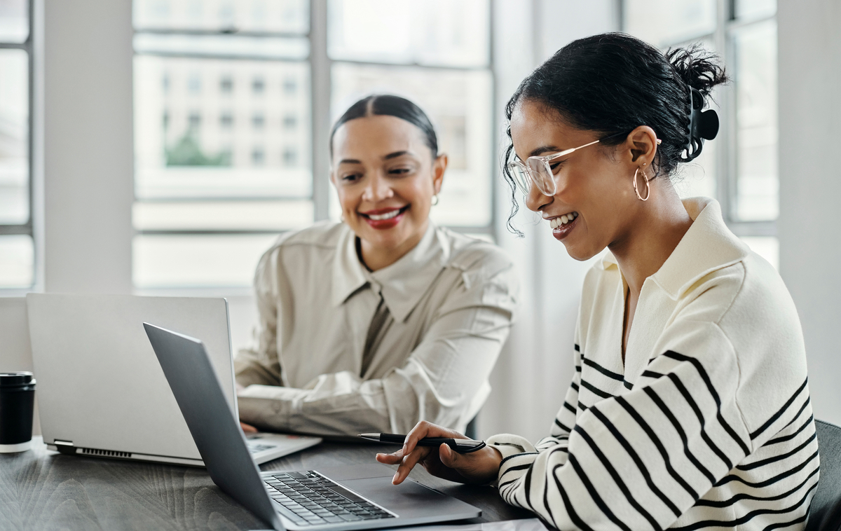 Business women, laptop and and happy team in office  for web design, collaboration and training. Planning, digital marketing and coaching by woman leader menor help, explain and support creative goal