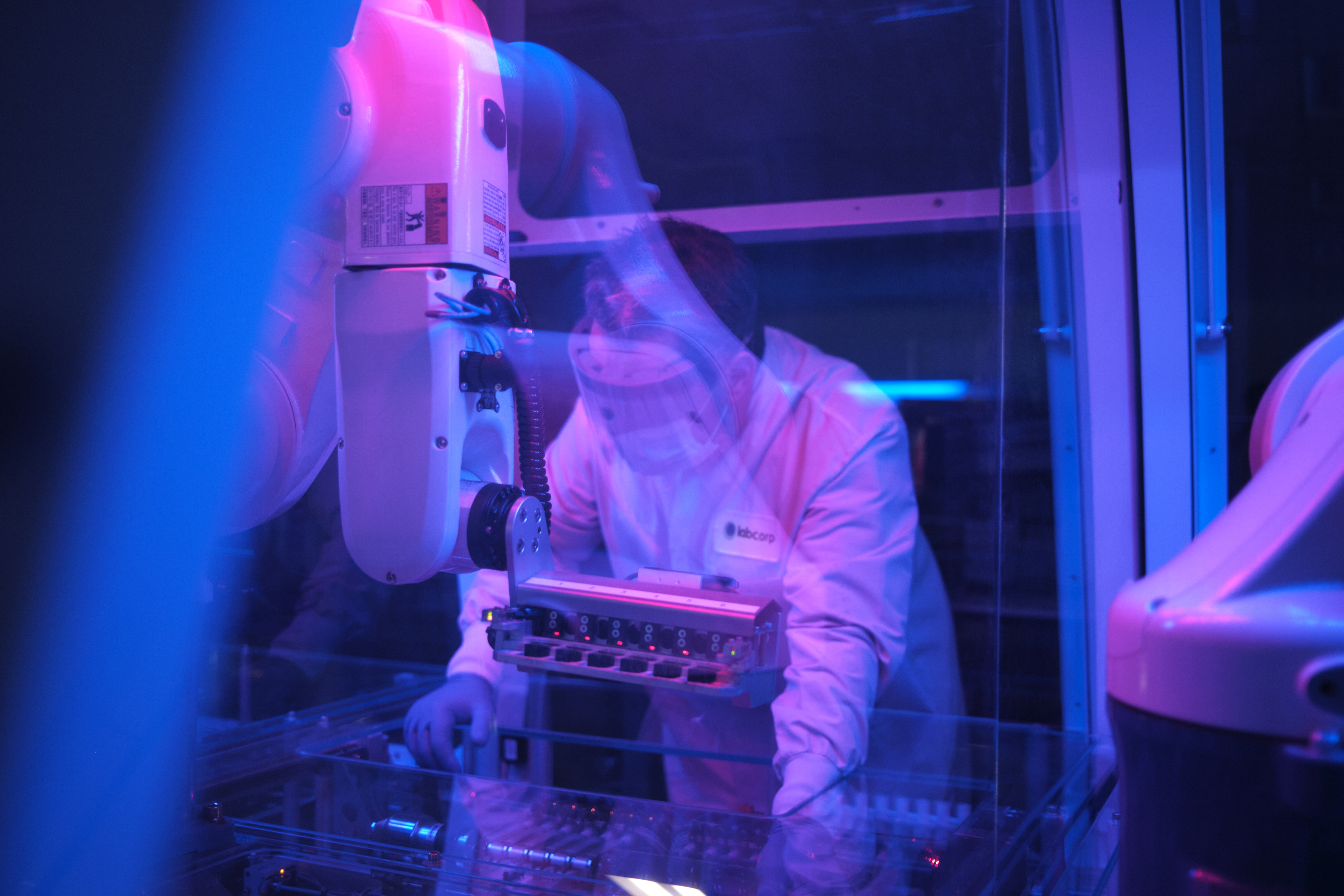 Labcorp scinetist in a lab with blue and purple lighting