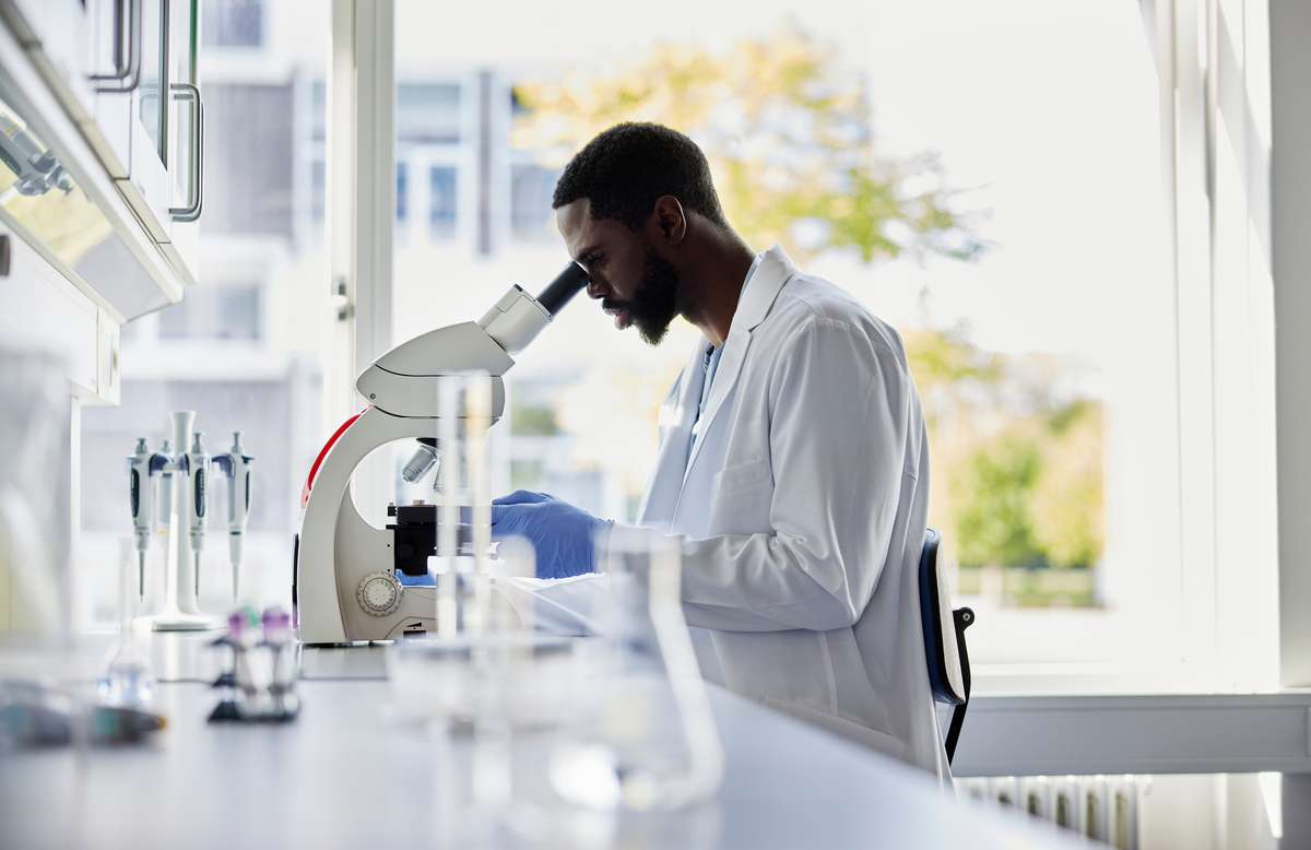 Scientist looking into a microscope at a lab